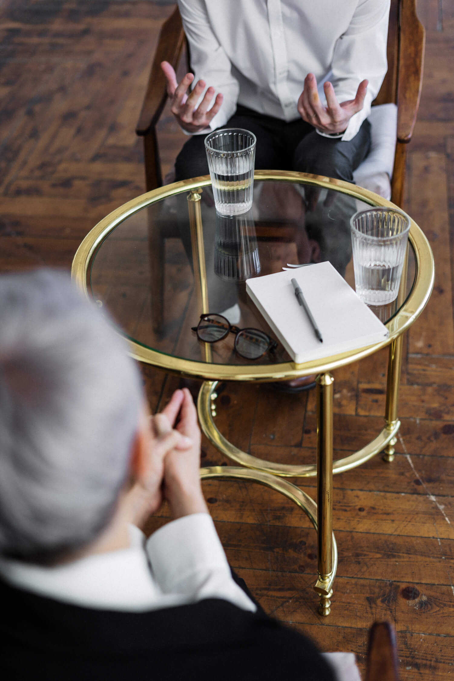 Zwei Herren sitzen an einem Glastisch und diskutieren